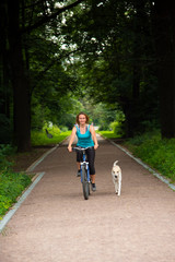 Fototapeta premium Girl on a bike ride with a dog