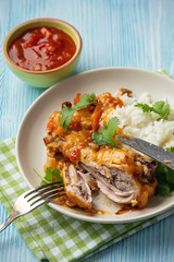 Chicken drumstick in tomato sauce with boiled rice.