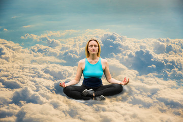 Fototapeta na wymiar Blonde doing yoga in the clouds