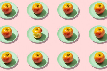 Fresh apples in plate on pink background. Vibrant colorful pattern