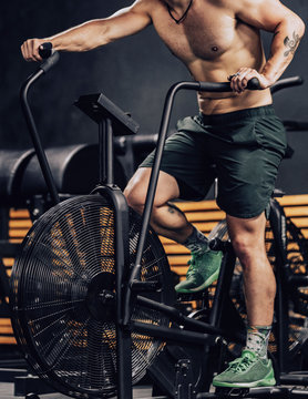 Strong man training on contemporary exercise bike in sport club