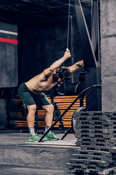Muscular man doing workout on upper-body machine in modern sport club