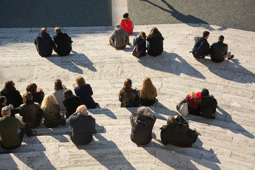 Crowd of people sitting on city stairs back behind top view. Concept of rest and meet in the city