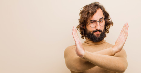 young bearded crazy man looking annoyed and sick of your attitude, saying enough! hands crossed up...