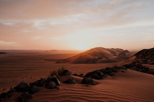 Cloudy sundown sky over hills and rocks in arid desert in evening in Morocco © Manuel Orts/ADDICTIVE STOCK