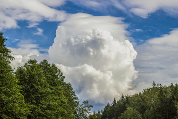 Big white cloud. A cumulus cloud is floating across the sky. Weather conditions before a thunderstorm.