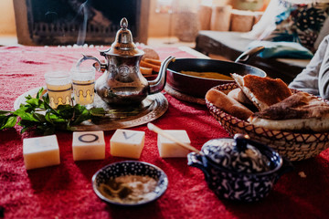 Set of traditional Arab dessert and tray with teapot and cups placed on table during traditional tea ceremony