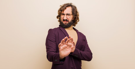 young bearded crazy man feeling disgusted and nauseous, backing away from something nasty, smelly...