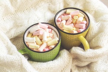 Winter holidays concept with cups of hot chocolate and colorful marshmallows