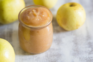 Apple sauce in glass jar on the white background