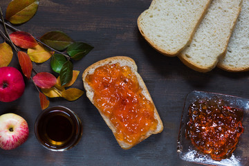 Top view of apple jam on the toast on brown background