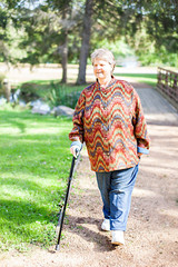 Smiling senior woman walking with cane in park, Portrait of happy granny resting outdoors