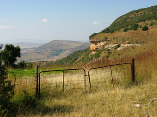 Old rusted farm gate on a farm mountain top.