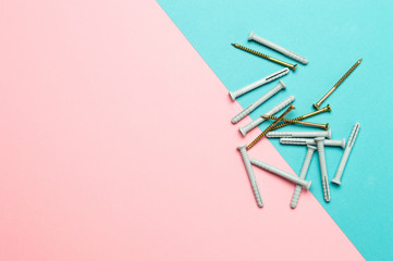 Plastic wall plugs and self-tapping screws on colored background