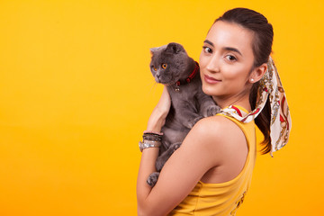 Obraz premium Portrait of beautiful girl holding adorable cat