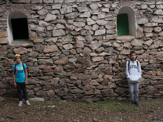 Fototapeta na wymiar boy looking at ruins of ancient ruined hermitage in the enchanted forest