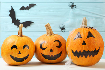 pumpkins with painted faces on a colored background for Halloween.