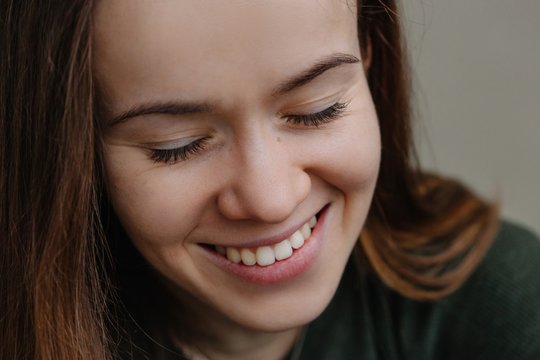 Closeup portrait of real woman laughing with closed eyes