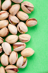 pistachos salados en un fondo verde toma zenital