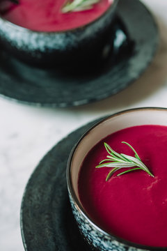beetroot cream soup with rosemary on white marble table