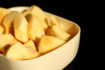 Quince in a plate on a black background. Cydonia oblonga