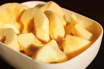 Quince in a plate on a black background. Cydonia oblonga