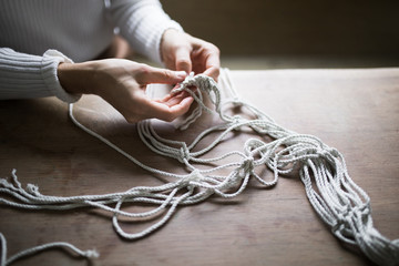 Woman's Hands Making Macrame Plant Hanger