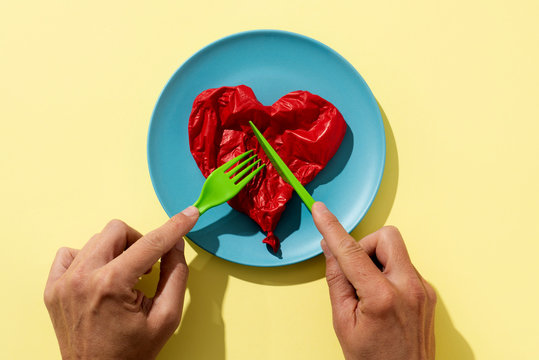 Man Eating A Deflated Red Balloon