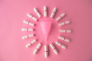 Vaginal cup and tampons on pink background. Flat lay