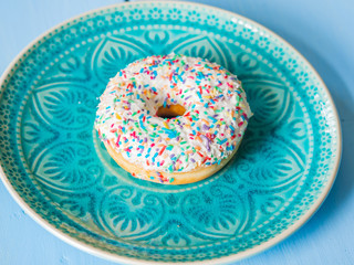 Delicious sprinkled white sweet donut - top view