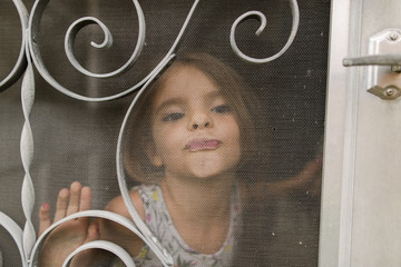 little girl looks out door