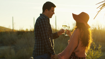 Couple holding hands and tasting white wine