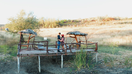 Beautiful couple clinking glasses with wine on a pontoon