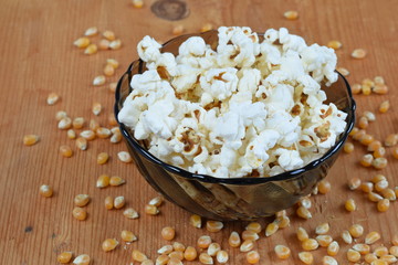 Popcorn in a glass bowl on wood