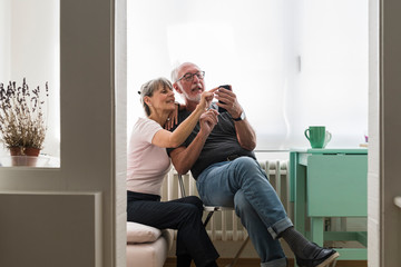 Senior couple using a phone at home