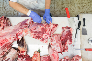 Butcher at work cutting fresh meat