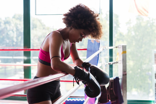 strong black woman resting after boxing workout