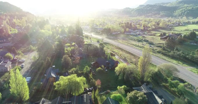 aereal drone footage in summer sunset in the Argentine Patagonia with vehicles arriving at the town