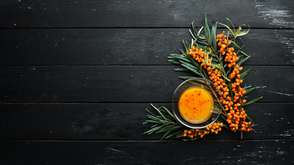 Drink from sea buckthorn berries. Winter hot drink. Fresh sea buckthorn on a twig. Top view. Free space for your text. - obrazy, fototapety, plakaty