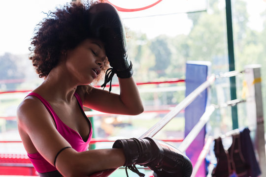 strong black woman resting after boxing workout
