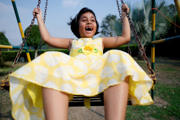 Little girl enjoying on a swing