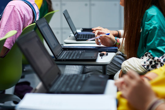 Teenage students using laptops