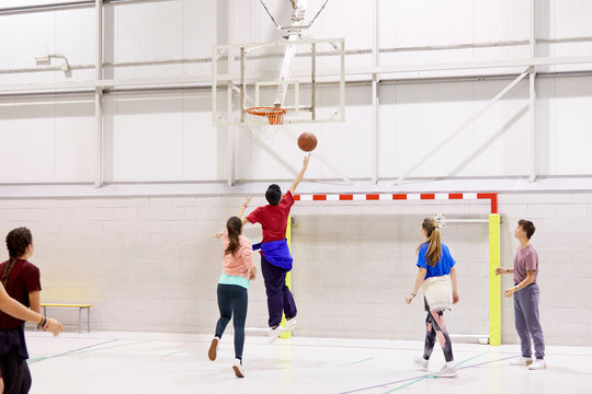 Teenage students playing basketball