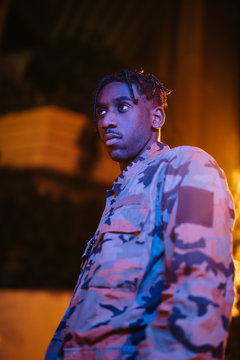 Stylish black guy standing on night street