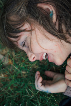 Young girl laughing in grass