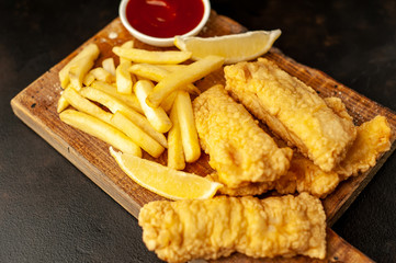 fish and chips with french fries, on a stone background  A