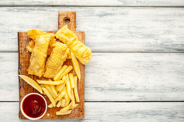 fish and chips with french fries, on wooden background