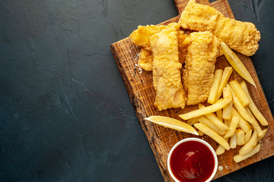 Fish And Chips With French Fries, On A Stone Background  A