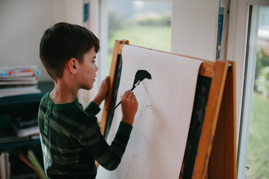 boy paints at easel