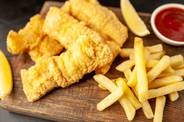 fish and chips with french fries, on a stone background  A